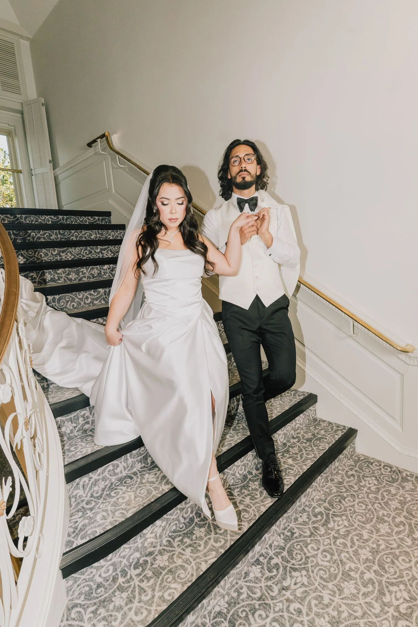 Newlyweds walking together on a bright staircase